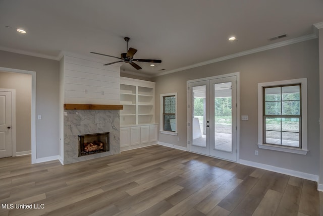 unfurnished living room with ornamental molding, light hardwood / wood-style flooring, and a fireplace