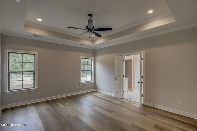 9070 Bennett Trl, Hernando, MS 38632 - empty room with a tray ceiling, crown molding, plenty of natural light, wood finished floors, and recessed lighting