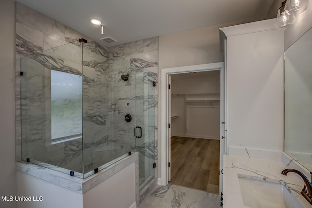 bathroom featuring vanity, an enclosed shower, and hardwood / wood-style floors