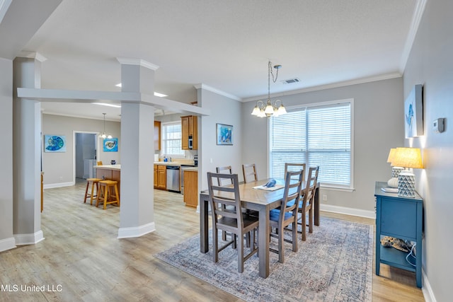 dining area with ornamental molding, an inviting chandelier, and light hardwood / wood-style floors