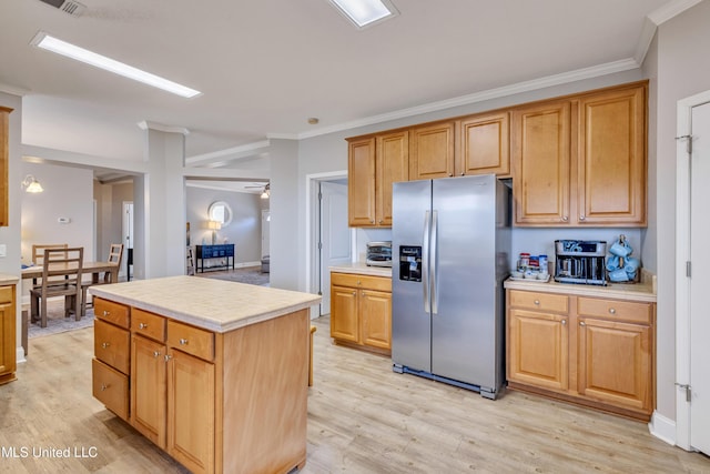 kitchen featuring crown molding, stainless steel fridge, a center island, and light wood-type flooring