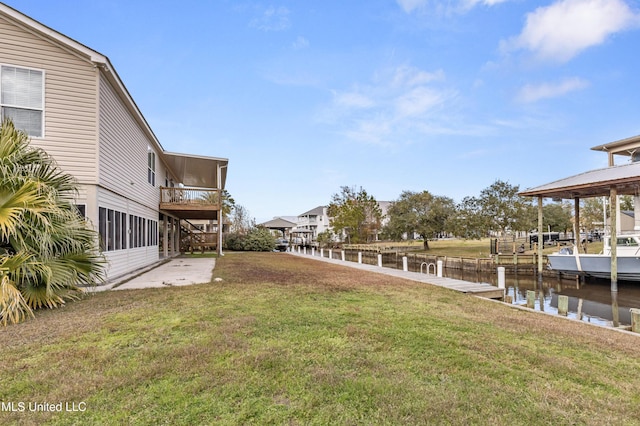 view of yard featuring a water view and a boat dock