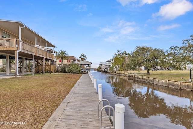 view of dock with a lawn and a water view