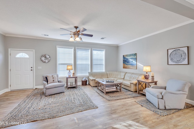 living room featuring ceiling fan, light hardwood / wood-style flooring, ornamental molding, and a textured ceiling