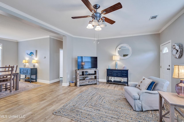 living room featuring hardwood / wood-style floors, crown molding, plenty of natural light, and ceiling fan