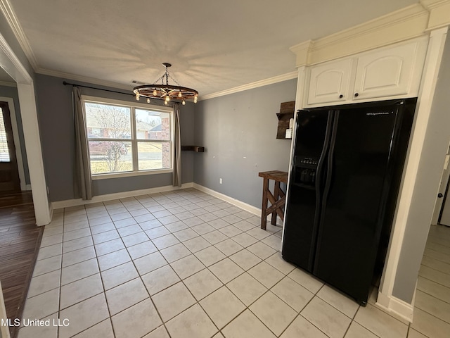 kitchen featuring a notable chandelier, black fridge, white cabinetry, and crown molding