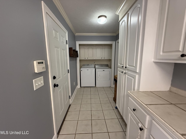 kitchen with washing machine and clothes dryer, light tile patterned floors, light countertops, ornamental molding, and a textured ceiling