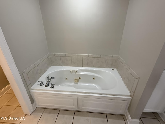 bathroom featuring tile patterned flooring, a jetted tub, and baseboards