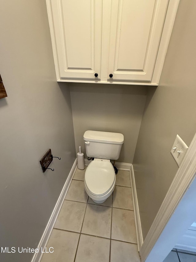 bathroom with tile patterned flooring, toilet, and baseboards