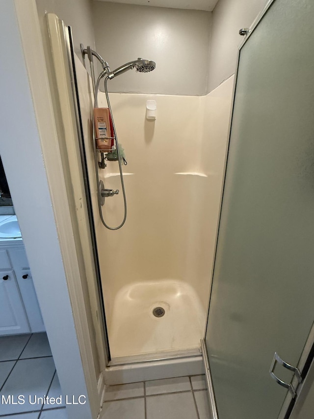 bathroom with a shower stall and tile patterned floors