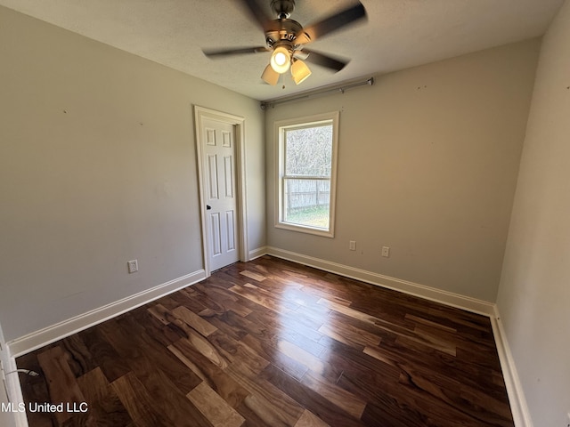 unfurnished room with dark wood-style floors, a ceiling fan, baseboards, and a textured ceiling