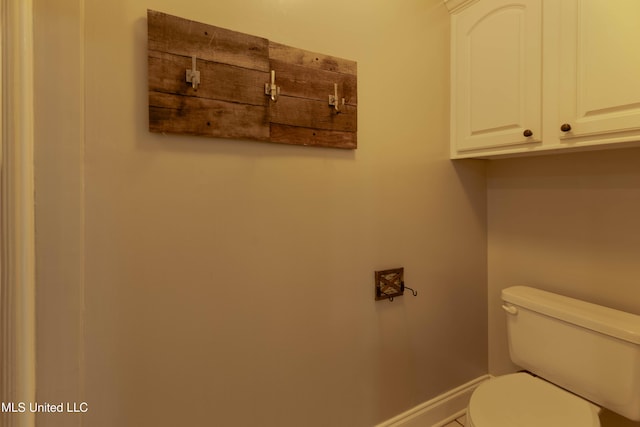 bathroom featuring baseboards and toilet