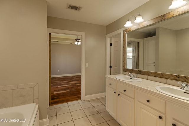 bathroom with ceiling fan, visible vents, a sink, and tile patterned floors