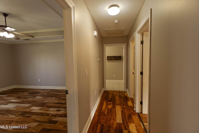 corridor featuring visible vents, baseboards, and dark wood finished floors