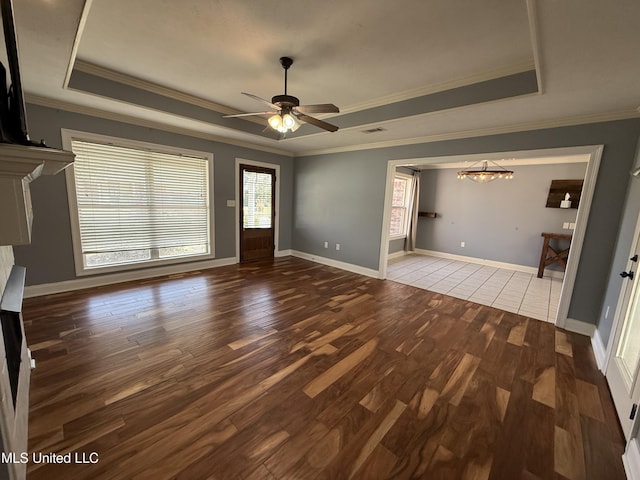 unfurnished living room with baseboards, a raised ceiling, and wood finished floors