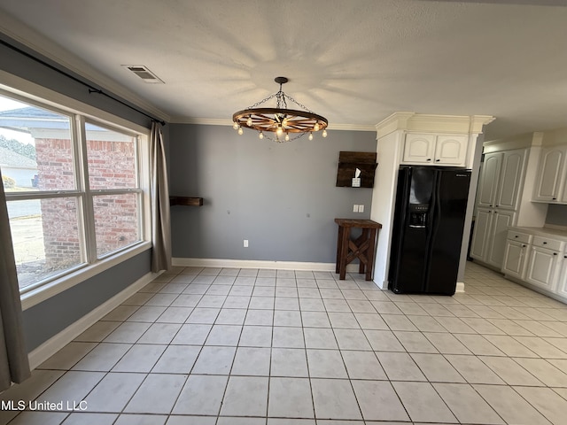 kitchen featuring visible vents, baseboards, white cabinetry, ornamental molding, and black fridge