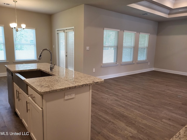 kitchen with baseboards, light stone counters, dark wood-type flooring, white cabinetry, and a sink