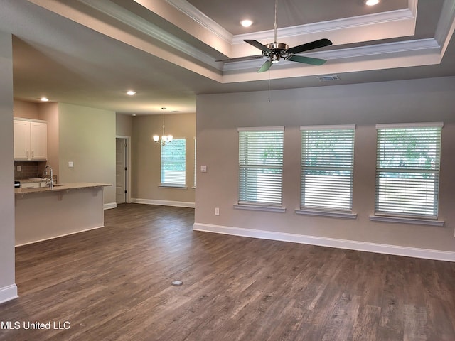 unfurnished living room with dark wood-style floors, a raised ceiling, visible vents, ornamental molding, and baseboards