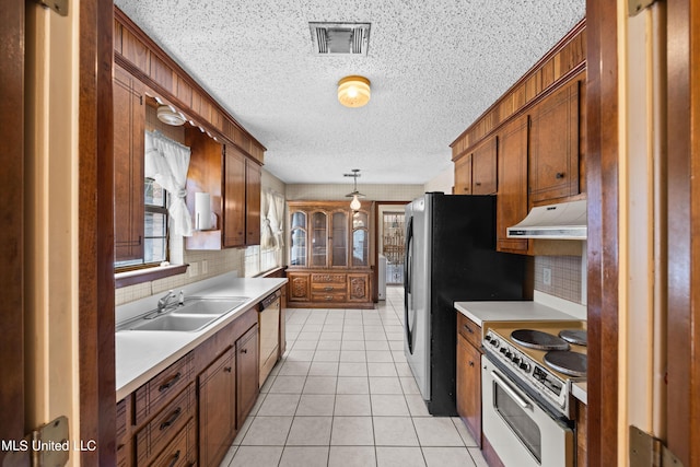 465 Heritage Pl, Jackson, MS 39212 - kitchen with white appliances, under cabinet range hood, a sink, a textured ceiling, and tasteful backsplash