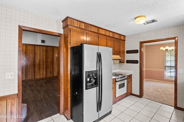 465 Heritage Pl, Jackson, MS 39212 - kitchen with stainless steel fridge, a chandelier, under cabinet range hood, white electric range oven, and a textured ceiling