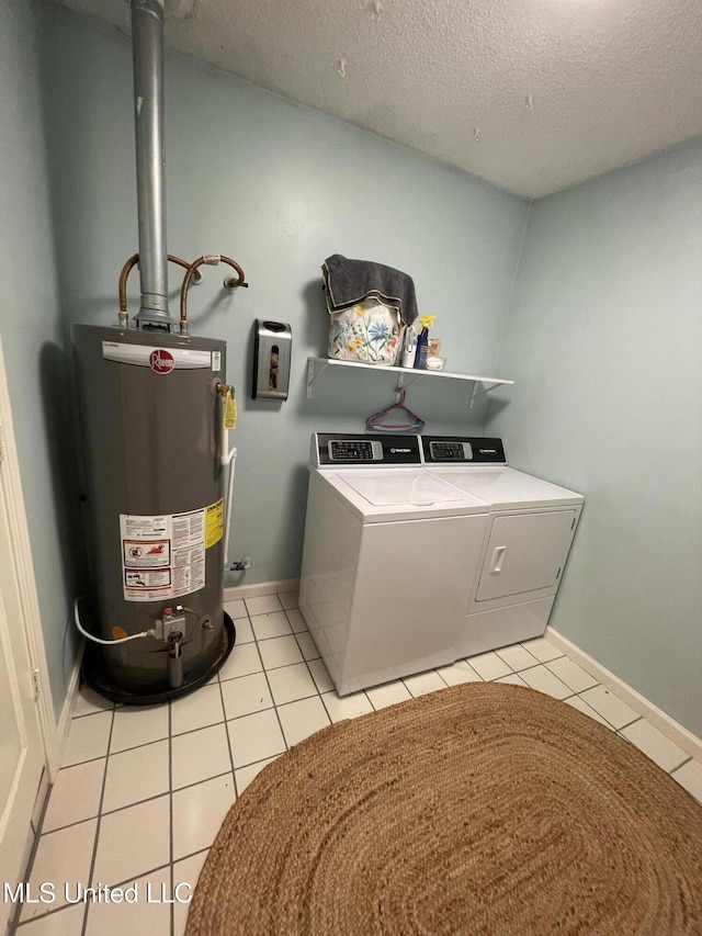 137 Phil Ln, Sardis, MS 38666 - washroom with water heater, washer and clothes dryer, a textured ceiling, and light tile patterned floors