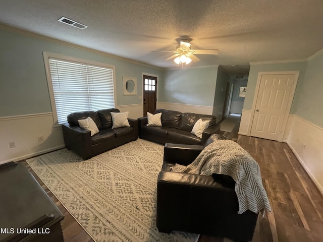 137 Phil Ln, Sardis, MS 38666 - living area featuring wainscoting, a textured ceiling, ornamental molding, dark wood-style flooring, and a ceiling fan