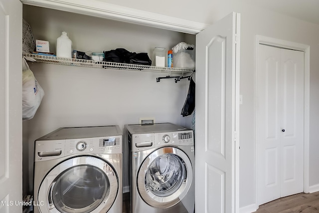 laundry room featuring washer and dryer, laundry area, and wood finished floors