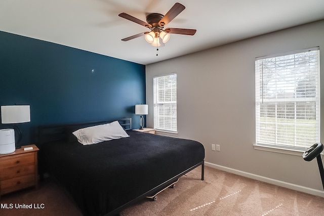 carpeted bedroom featuring ceiling fan, multiple windows, and baseboards