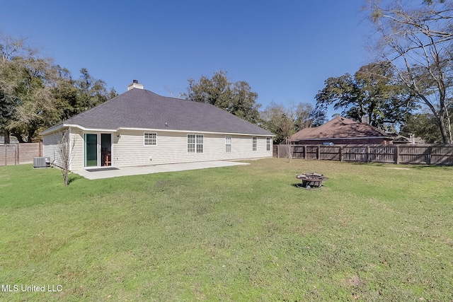 back of property featuring an outdoor fire pit, a fenced backyard, a yard, and central air condition unit