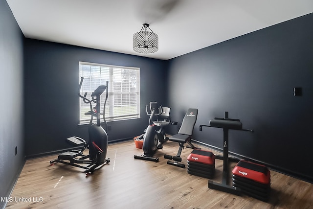 exercise room with light wood-style floors and baseboards