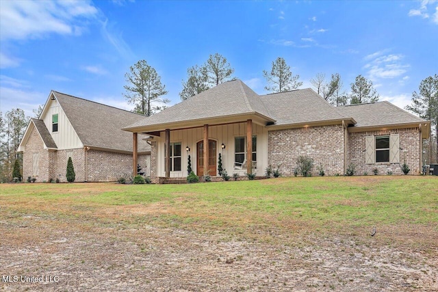 view of front of property featuring covered porch, a front lawn, board and batten siding, and brick siding