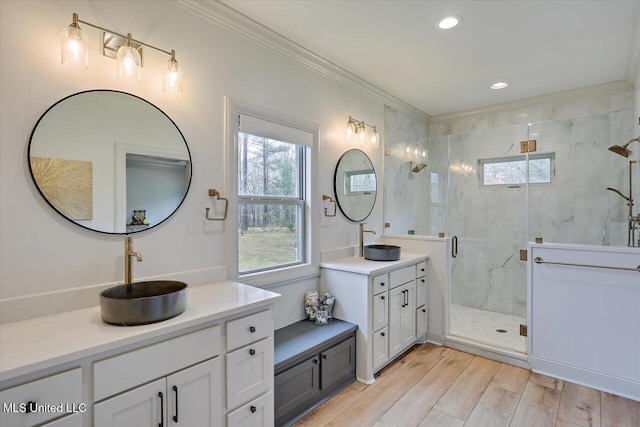 full bath featuring crown molding, a sink, a marble finish shower, and wood finished floors