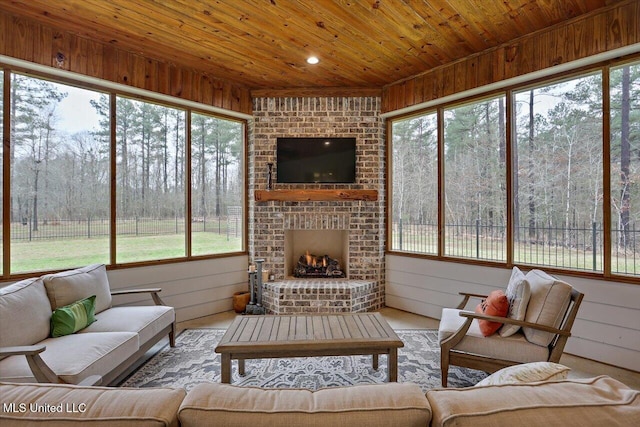 sunroom / solarium featuring a brick fireplace and wood ceiling