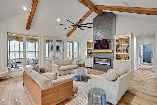 living area with a glass covered fireplace, light wood-style flooring, french doors, high vaulted ceiling, and beam ceiling