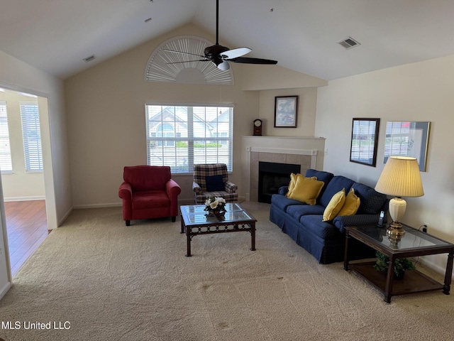 living room with vaulted ceiling, a ceiling fan, plenty of natural light, carpet flooring, and a fireplace