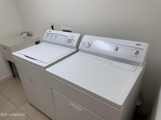 laundry area featuring washer and dryer and light tile patterned floors