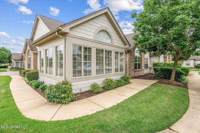 8761 Parkview Oaks Cir, Olive Branch, MS 38654 - view of side of home with brick siding, roof with shingles, and a yard