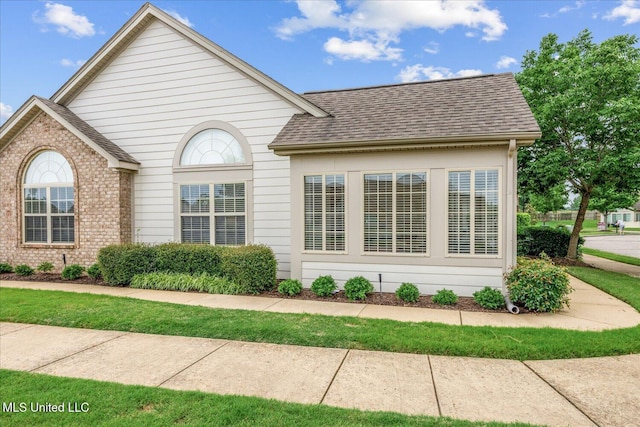 8761 Parkview Oaks Cir, Olive Branch, MS 38654 - view of side of home featuring a shingled roof and brick siding