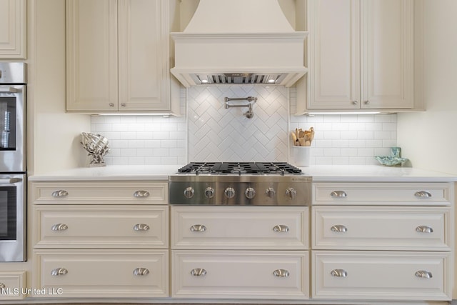 kitchen featuring stainless steel appliances, light countertops, custom exhaust hood, and tasteful backsplash