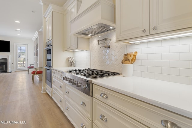 kitchen featuring tasteful backsplash, light countertops, ornamental molding, and custom range hood