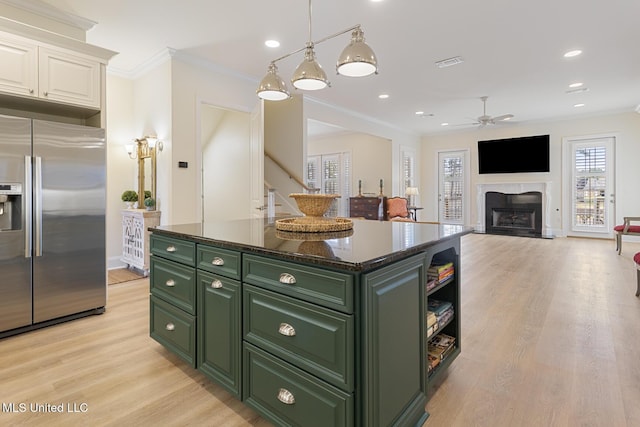 kitchen featuring green cabinets, stainless steel fridge, white cabinetry, and crown molding