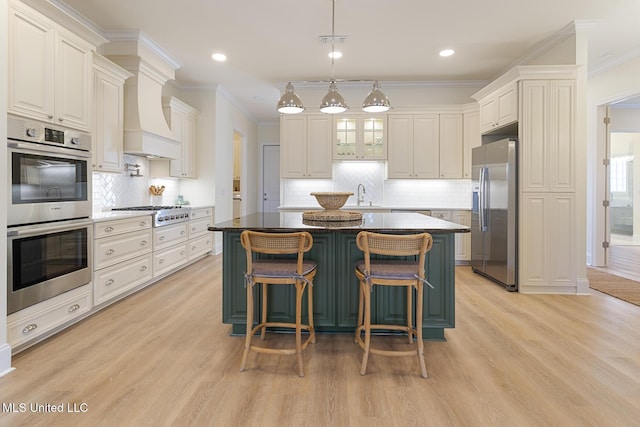 kitchen featuring stainless steel appliances, a kitchen island, a sink, and crown molding