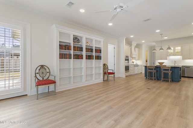 interior space with crown molding, a breakfast bar, visible vents, and a sink