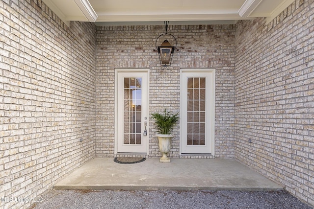 view of exterior entry featuring brick siding