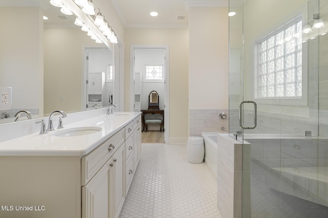 bathroom with a garden tub, ornamental molding, a sink, and tile patterned floors