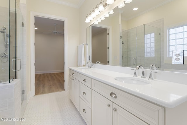 bathroom with a stall shower, ornamental molding, a sink, and tile patterned floors