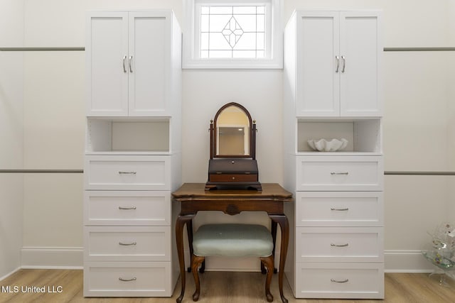 home office with light wood-style flooring and baseboards