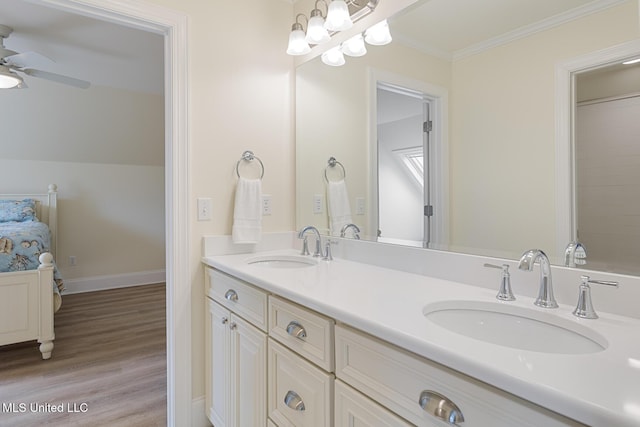 full bathroom with baseboards, wood finished floors, a sink, and crown molding