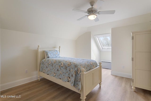 bedroom with light wood finished floors, ceiling fan, baseboards, and lofted ceiling with skylight