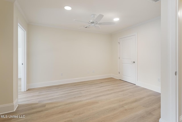 empty room with ornamental molding, light wood-style flooring, and baseboards